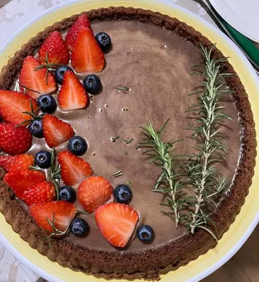 a chocolate pie with strawberries and blueberries on a plate at Due Passi Suite in Palermo