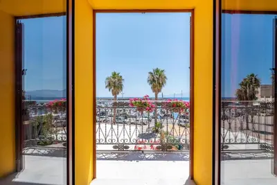 a yellow door with a view of the beach at Stenopus Greco Casa per AFFITTI TURISTICI in Santa Flavia