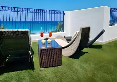 a patio with chairs and a table with a view of the ocean at Hotel Egitarso Sul Mare in San Vito lo Capo