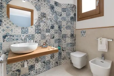 a bathroom with a sink and a toilet and a mirror at B&B Acqua Azzurra in San Vito lo Capo