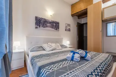a bedroom with a bed with a blue and white comforter at Kasavucciria Apartments in Palermo