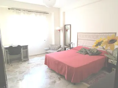 a bedroom with a red bed with a flower on it at Appartamento Libertà in Palermo