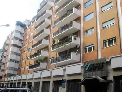 a tall apartment building with balconies on a street at Appartamento Libertà in Palermo