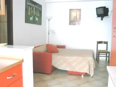 a bedroom with a bed with a couch and a tv at Appartamento Libertà in Palermo