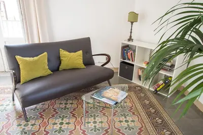 a living room with a black couch and a coffee table at Aria Rooms in Palermo