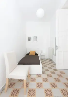 a white bedroom with a bed and a chair at Dimora CentroWell in Palermo