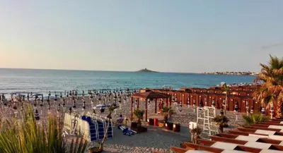 a beach with a crowd of people and the ocean at 
