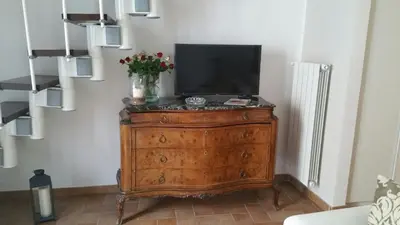 a television on top of a wooden dresser in a room at Penthouse Luxury Quattro Canti in Palermo