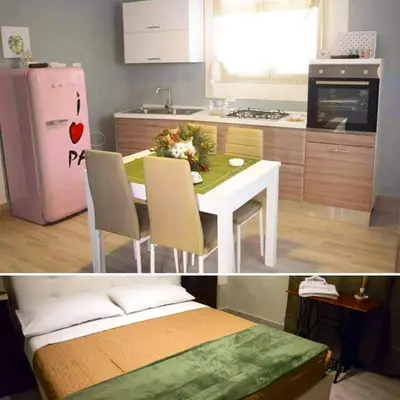 a kitchen with a white table and a pink refrigerator at Le Case di Ninni in Palermo