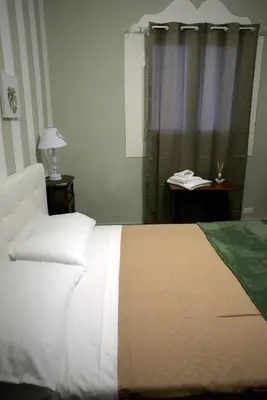 a bedroom with a white bed and a lamp and a window at Le Case di Ninni in Palermo
