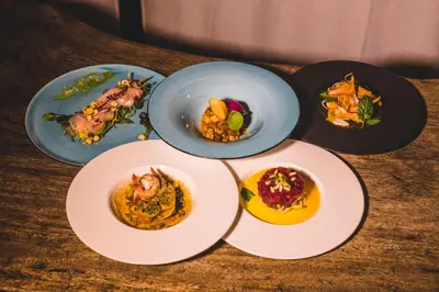 four plates of food on a wooden table at LuminHouse Mondello Arancia in Mondello