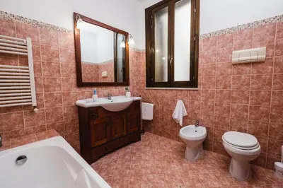 a bathroom with a tub and a toilet and a sink at LuminHouse Mondello Fico in Mondello