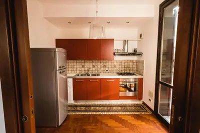 a kitchen with brown cabinets and a stainless steel refrigerator at LuminHouse Mondello Zibibbo in Mondello