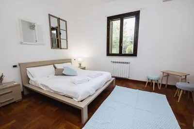 a bedroom with a bed and a table and a window at LuminHouse Mondello Zibibbo in Mondello
