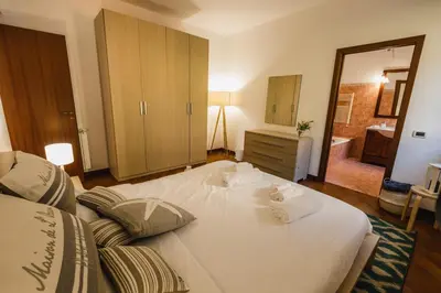 a bedroom with a large white bed and a mirror at LuminHouse Mondello Limone in Mondello