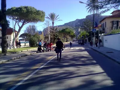 a person walking down a street in a city at Near the beach in Palermo