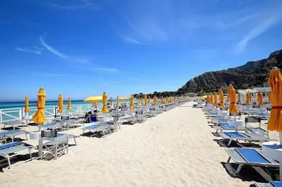 a beach with chairs and umbrellas and the ocean at Near the beach in Palermo