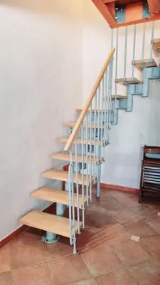 a wooden staircase in a room with a tiled floor at Casa Vacanza Brigida in Scopello
