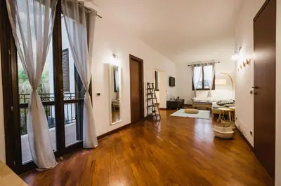 a living room with wooden floors and a large window at LuminHouse Villa Mondello in Mondello