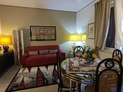 a living room with a table and a red couch at Pretty house in Palermo