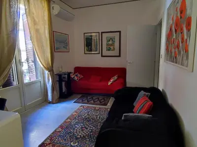 a living room with a red couch and a rug at Pretty house in Palermo