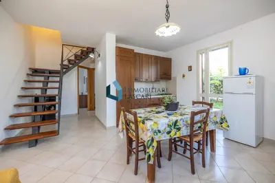 a kitchen and dining room with a table and chairs at Villa Siragusa con piscina condominiale in Campofelice di Roccella