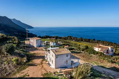 an aerial view of a house with the ocean in the background at La Finestra sul Mare dello Zingaro in Scopello