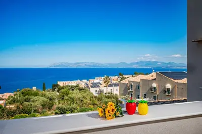 a view of the ocean from a window with fruit on a ledge at La Finestra sul Mare dello Zingaro in Scopello