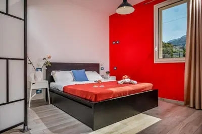 a red bedroom with a bed with a red wall at La Finestra sul Mare dello Zingaro in Scopello