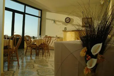 a dining room with a table and chairs and a clock at Torre Salina in Macari