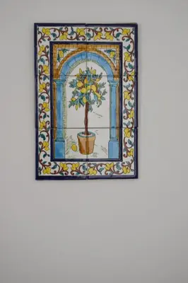 a mosaic picture of a tree in a pot on a wall at Le Volte - Locazione Turistica in Terrasini