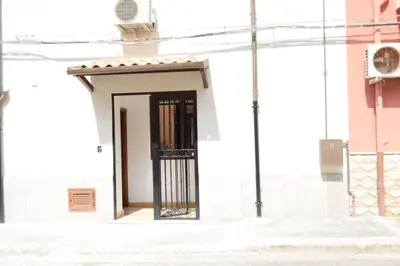 a door in a white building with a gate at Le Volte - Locazione Turistica in Terrasini