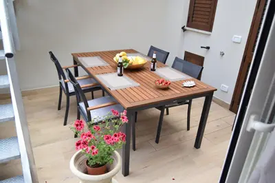 a dining room table and chairs with a bowl of fruit at Caporama in Terrasini