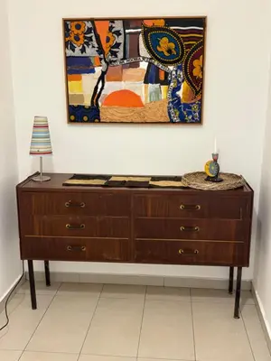 a wooden dresser in a room with a painting on the wall at Casa in villa vista mare in Palermo