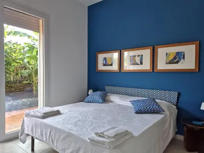 a bedroom with a bed with blue walls and a window at Casa in villa vista mare in Palermo