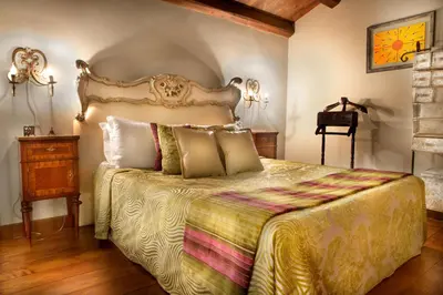 a bedroom with a large bed with a gold bedspread at Il Baglio Della Luna Relais by Le Dhome Sicily in Balestrate