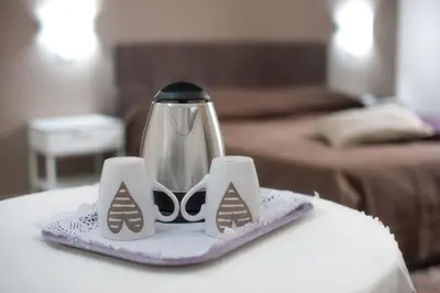 a coffee pot and two cups on a table at Casa Genna in Isola delle Femmine