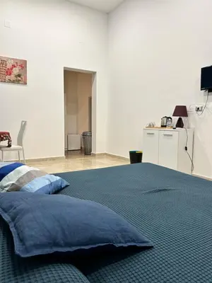 a bedroom with a large bed with blue pillows at Casa Genna in Isola delle Femmine