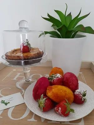 a table with a plate of strawberries and a cake at Le Casette di Marcì in Palermo
