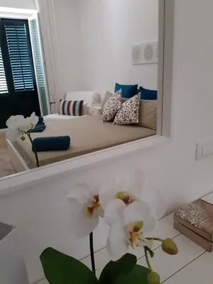 a mirror in a bedroom with a bed and flowers at Le Casette di Marcì in Palermo