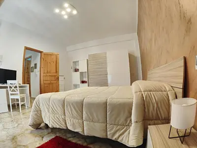 a bedroom with a large bed and a table and a chair at Casa Vacanza Isola sul Mare in Castellammare del Golfo