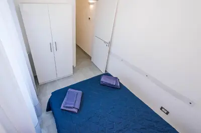 a bedroom with a blue bed with two purple cushions on it at Villa Sara in Lascari