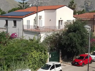 a white house with cars parked in front of it at Principessa Jolanda in Mondello