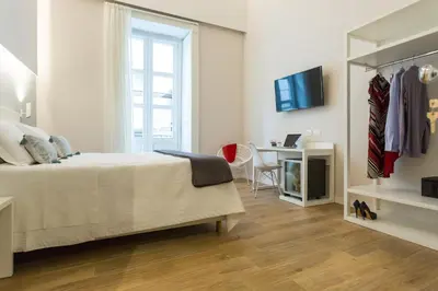 a white bedroom with a bed and a desk at Bellaroto Suite & Spa - Charming Boutique Rooms in Palermo