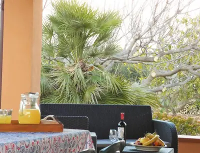 a table with a plate of food and a bottle of wine at Villa Indipendente Jacuzzi Giardino Clima WiFi in Castellammare del Golfo