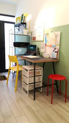 a desk with a computer and a red stool at A Palermo Sono in Palermo