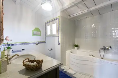 a white bathroom with a tub and a sink at Large terrace apartment near Politeama in Palermo