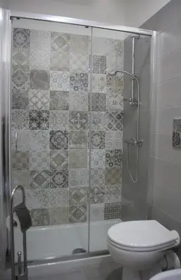 a bathroom with a glass shower with a toilet at Mantegna Rooms in Palermo