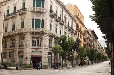 a large white building on a city street at Mantegna Rooms in Palermo