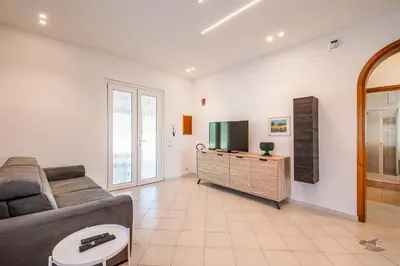 a living room with a couch and a flat screen tv at Villa DellAcqua in Alcamo Marina